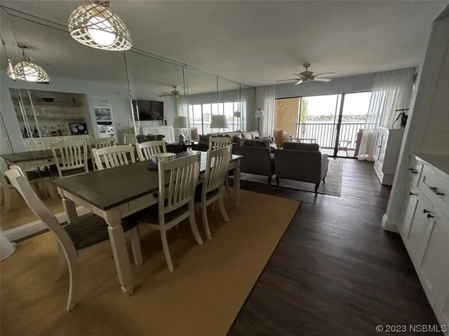 a view of a dining room with furniture a chandelier and wooden floor