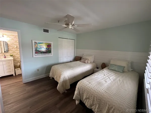 a bedroom with two beds and a chandelier