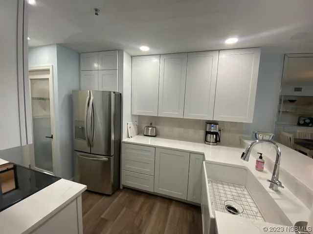 a kitchen with a refrigerator sink and cabinets