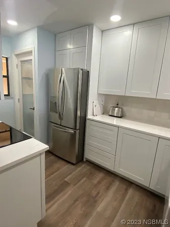 a kitchen with a refrigerator sink and cabinets