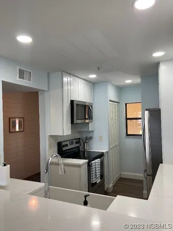 a kitchen with a refrigerator and a stove top oven