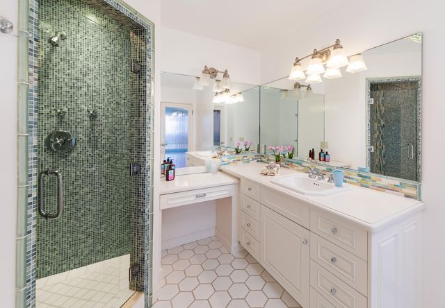 a bathroom with a double vanity sink mirror and shower