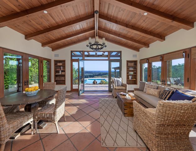 a living room with furniture a chandelier and a large window