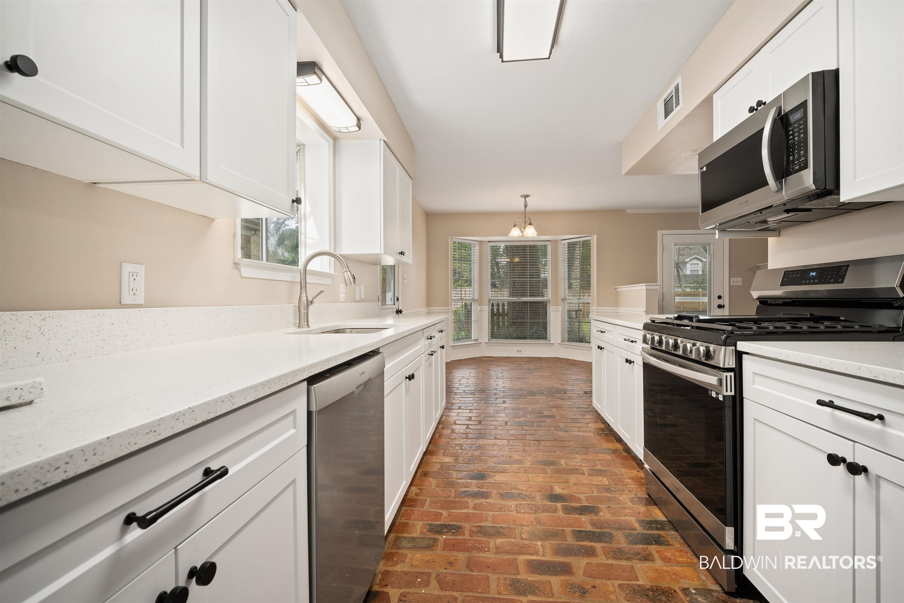 804 Wildwood Avenue Mobile, AL 36609 - Photo 8 of 30 Kitchen featuring pendant lighting, stainless steel appliances, sink, white cabinetry, and light stone counters