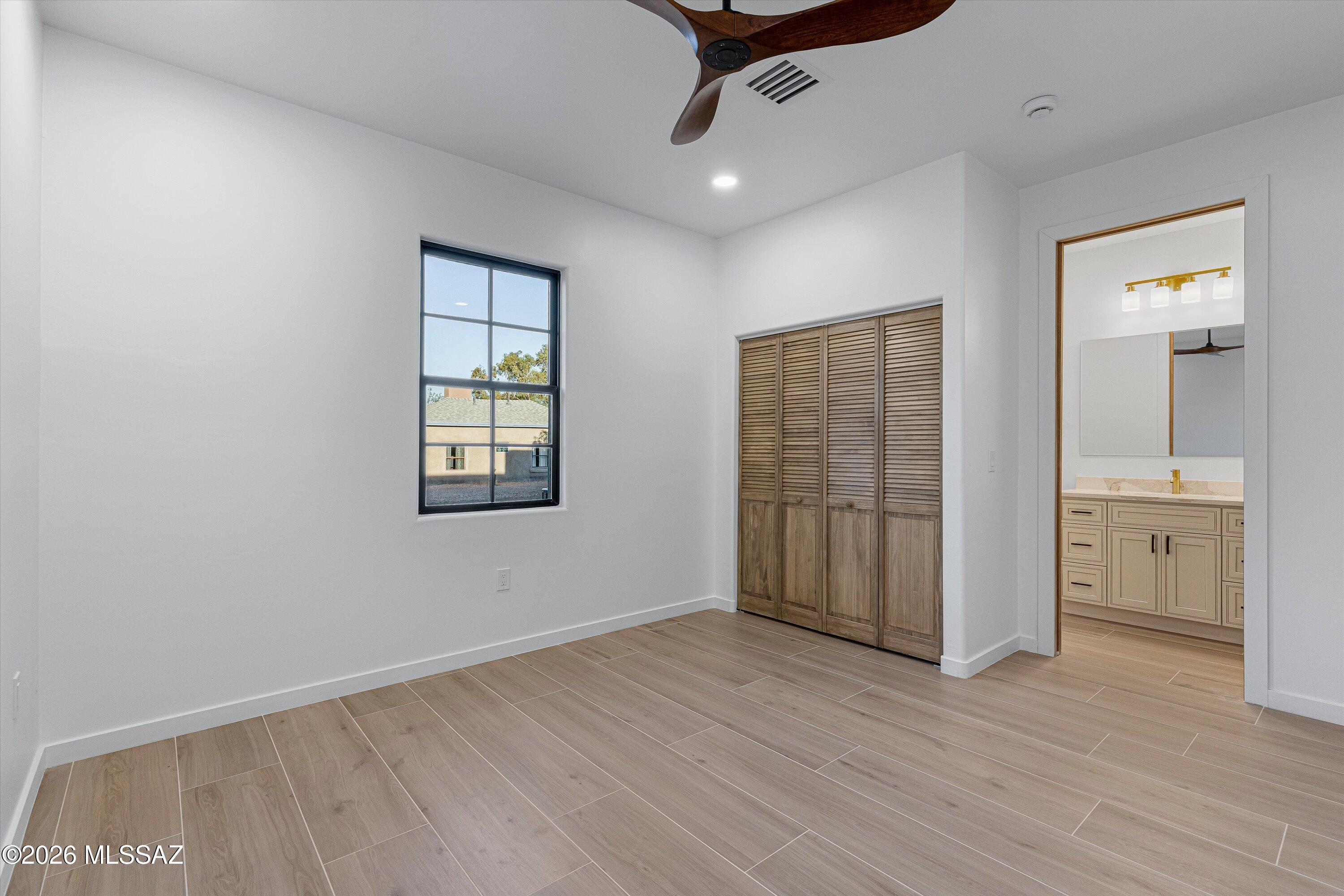 5259 East Fort Lowell Road Tucson, AZ 85712 - Photo 27 of 50 an empty room with wooden floor cabinet and windows