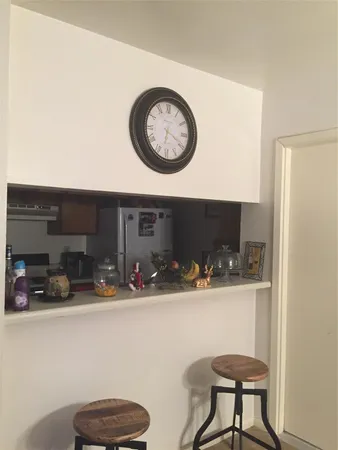 a view of a hallway with a table and a clock