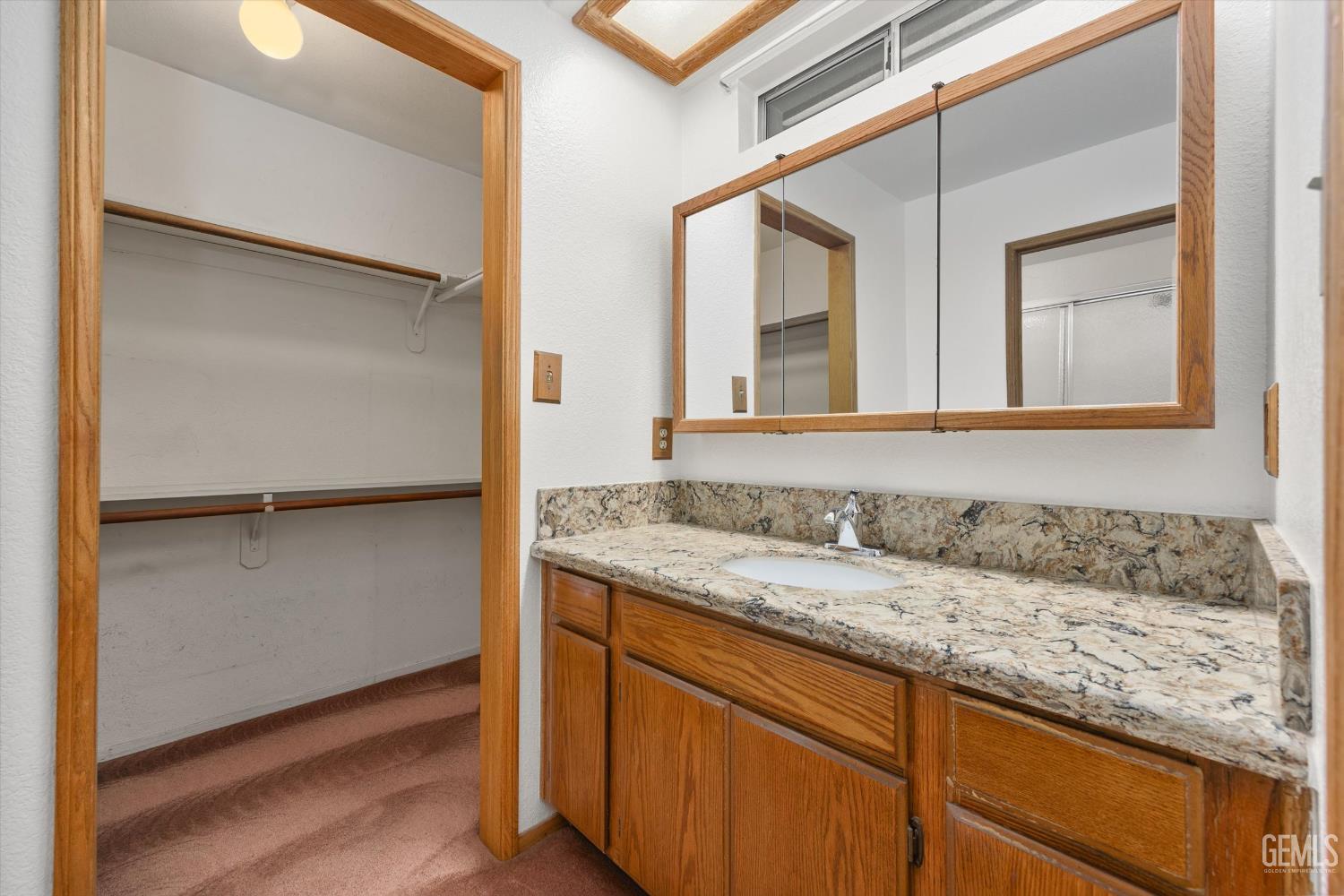 Undisclosed Address Bakersfield, CA 93307 - Photo 13 of 26 a bathroom with a granite countertop sink and a mirror
