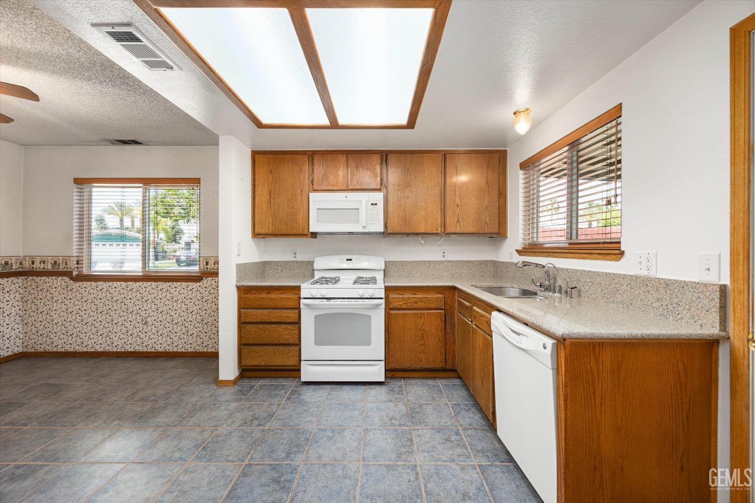 Undisclosed Address Bakersfield, CA 93307 - Photo 10 of 26 a kitchen with a stove a sink and a refrigerator