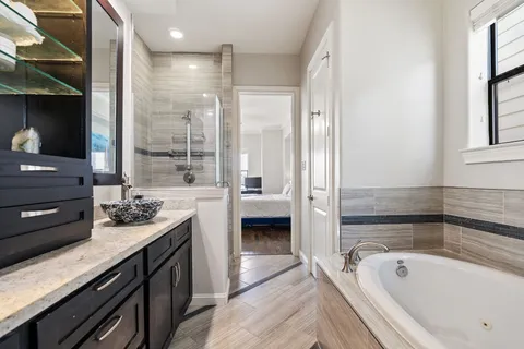 a bathroom with a tub a sink and mirrors