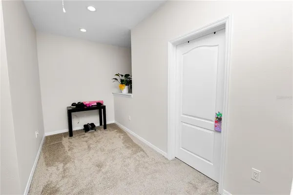 a hallway with table and white cabinet