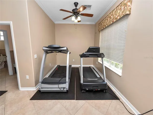 a room with gym equipment and a chandelier