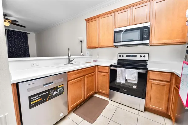 a kitchen with stainless steel appliances a stove microwave and sink