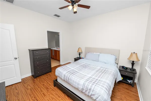 a bedroom with a bed and wooden floor