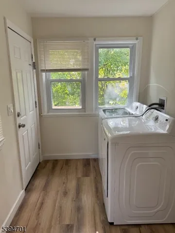 a utility room with wooden floor washer and dryer