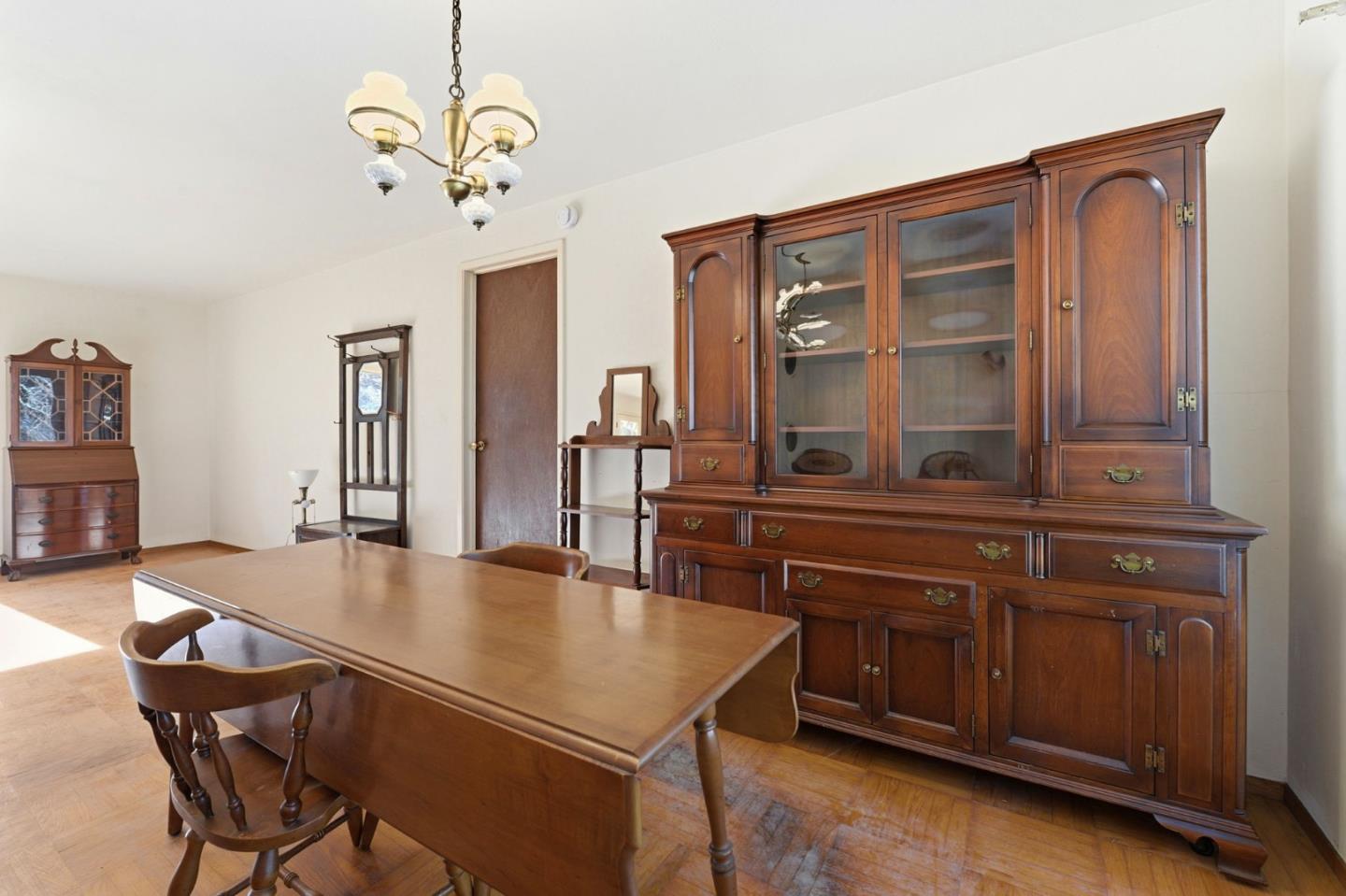 3915 Kingridge Drive San Mateo, CA 94403 - Photo 19 of 47 a dining room with wooden floor a chandelier a wooden table and chairs