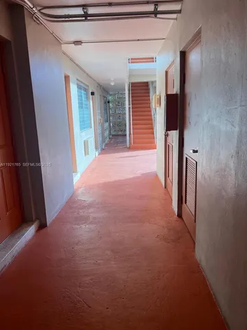 a view of a hallway with wooden walls and stairs
