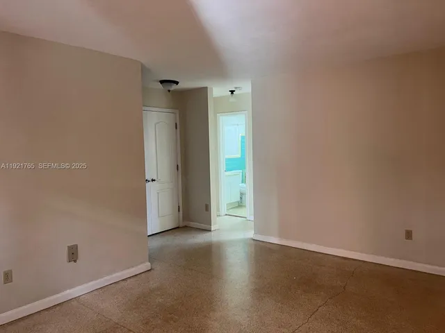 an empty room with closet and wooden door