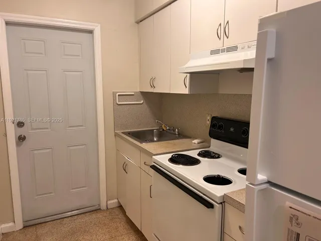 a kitchen with a sink a stove and cabinets