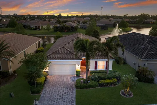 an aerial view of house with yard and lake view in back