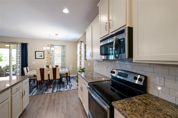 a kitchen with granite countertop lots of counter top space a sink a stove and a window