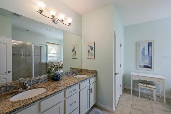 a bathroom with a granite countertop sink a mirror and a shower