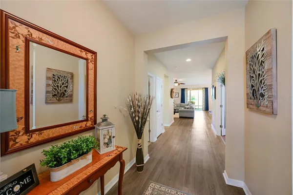 a view of a hallway with wooden floor and a potted plant