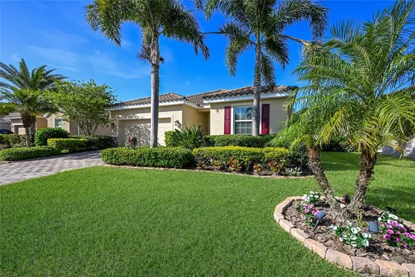 a front view of a house with a garden and yard