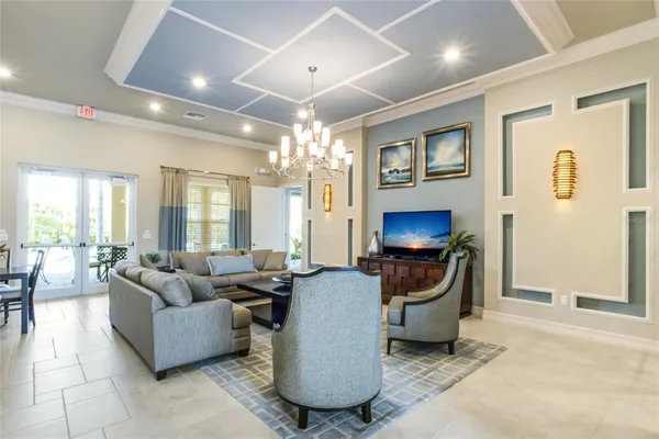 a living room with furniture a chandelier and a large mirror