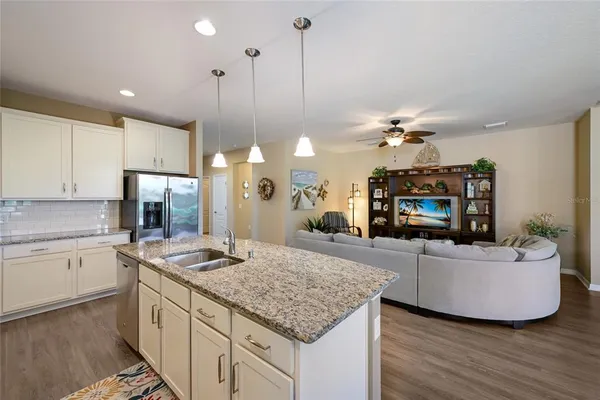 a kitchen with kitchen island a counter top space a sink stainless steel appliances and cabinets