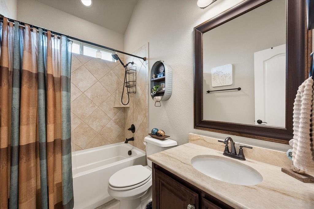 445 Rusty Run Drive Midlothian, TX 76065 - Photo 29 of 40 a bathroom with a granite countertop sink toilet a mirror a vanity and shower