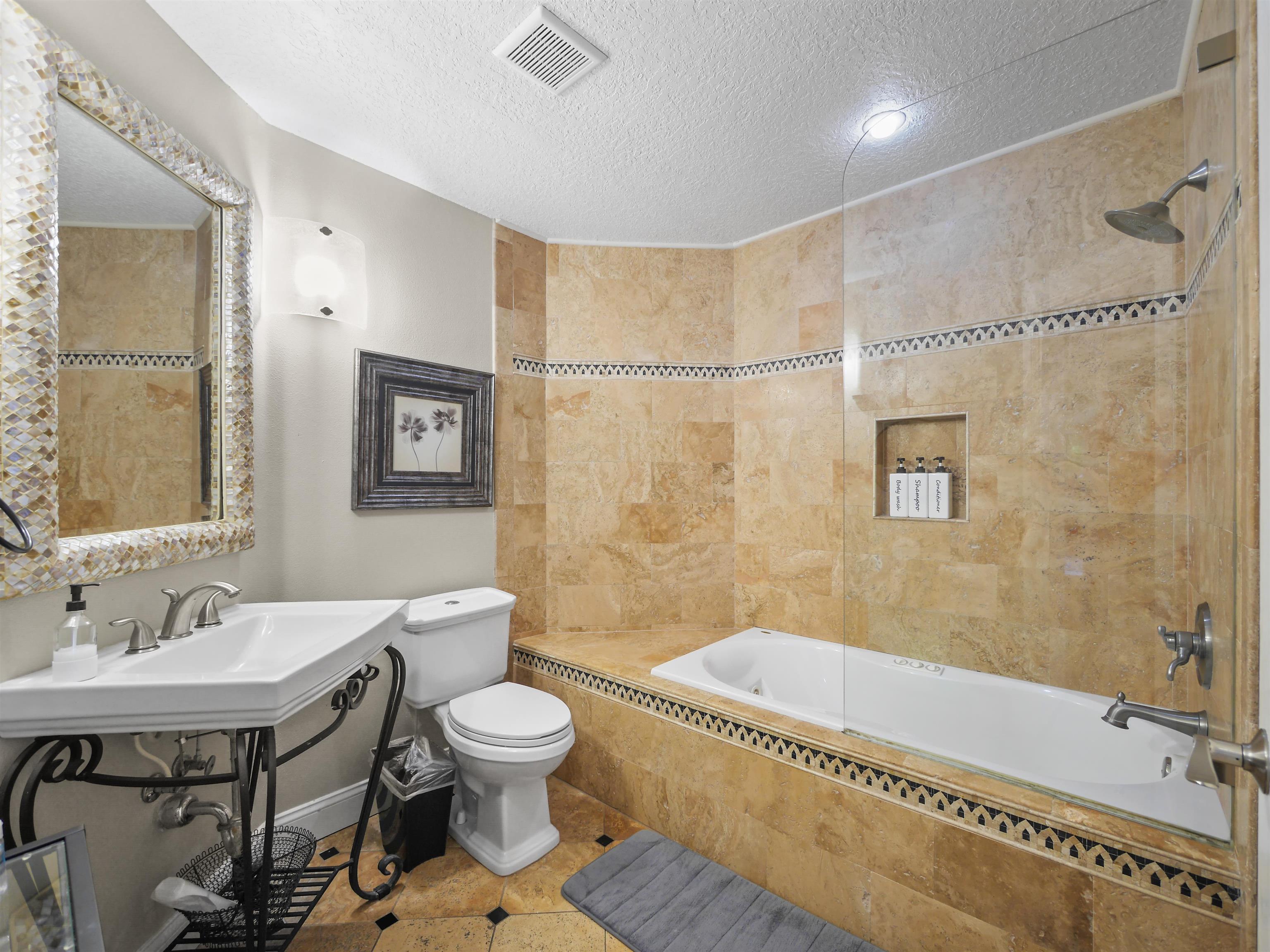 5301 1st Street St. Augustine, FL 32080 - Photo 17 of 36 a bathroom with a sink a toilet a mirror and a bathtub
