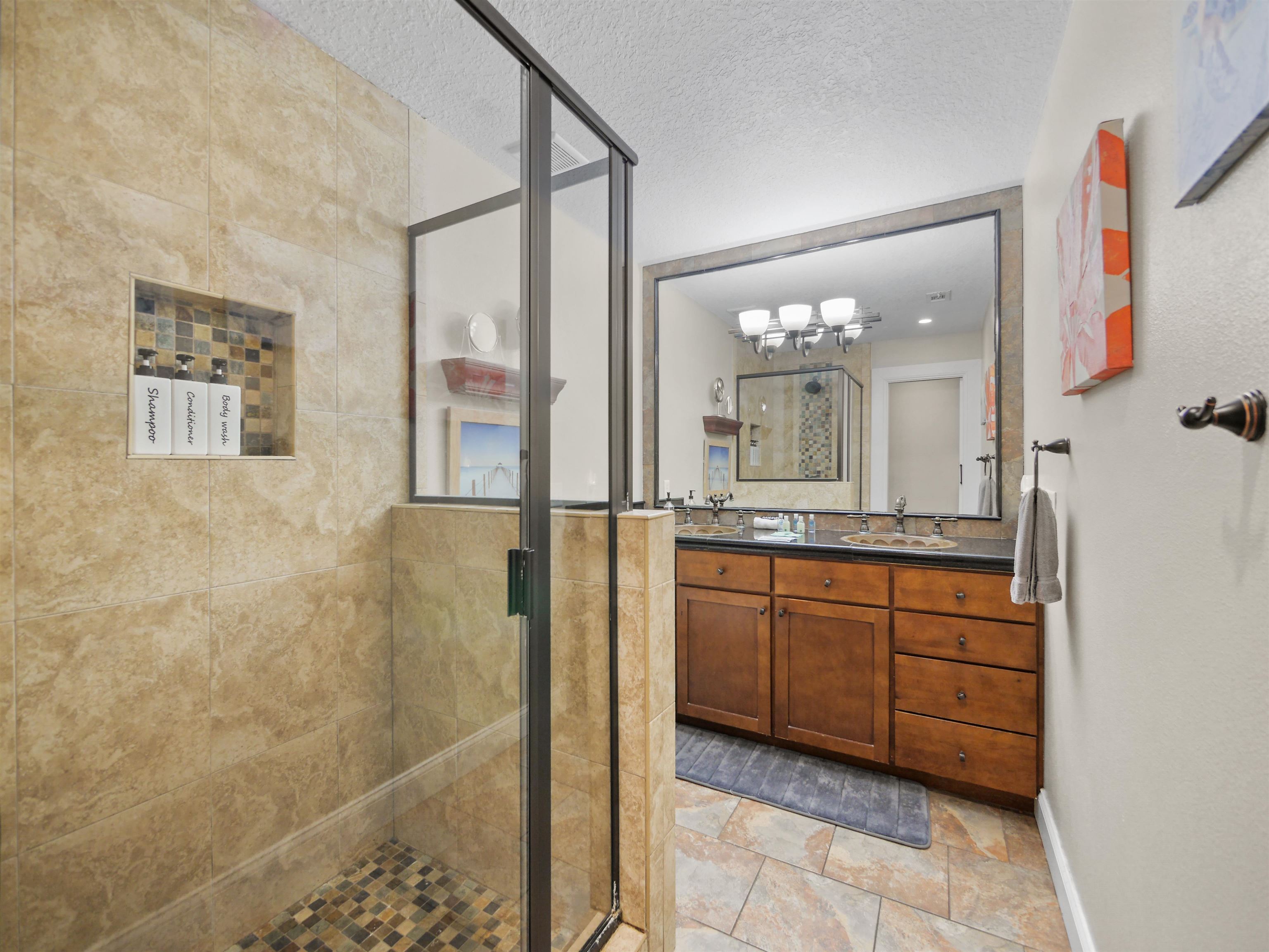 5301 1st Street St. Augustine, FL 32080 - Photo 21 of 36 a bathroom with a granite countertop sink a mirror and a shower