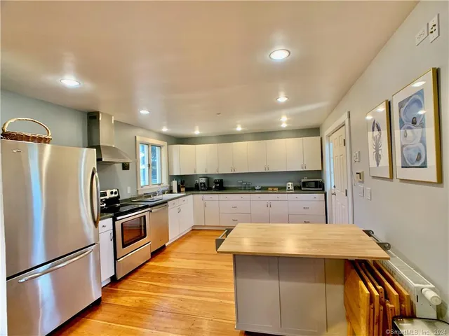 a kitchen with stainless steel appliances granite countertop a refrigerator a sink and a stove