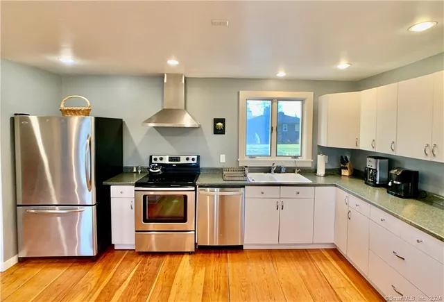 a kitchen with stainless steel appliances a stove a sink and a refrigerator