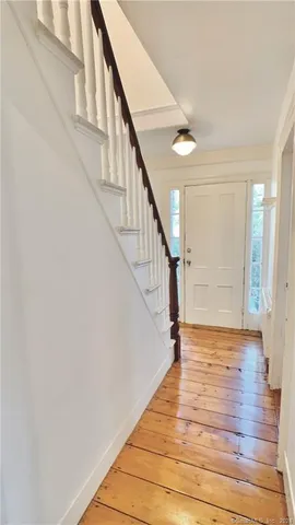 a view of entryway and hall with wooden floor