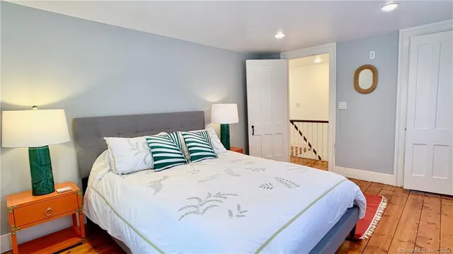 a bedroom with a bed and painting on the wall