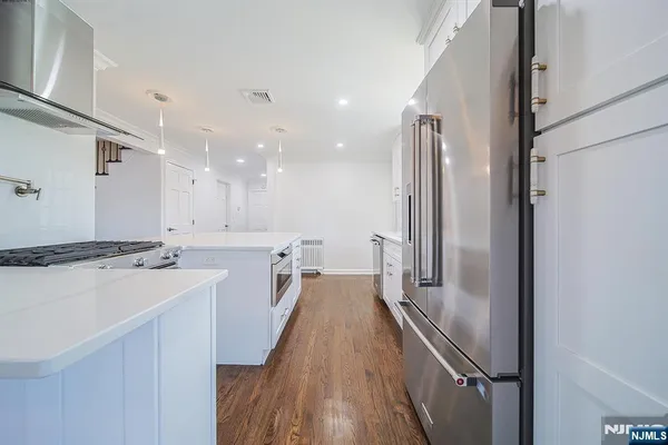 a view of a kitchen with a stove a refrigerator and a sink