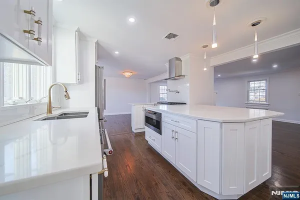 a kitchen with counter top space a sink stainless steel appliances and cabinets