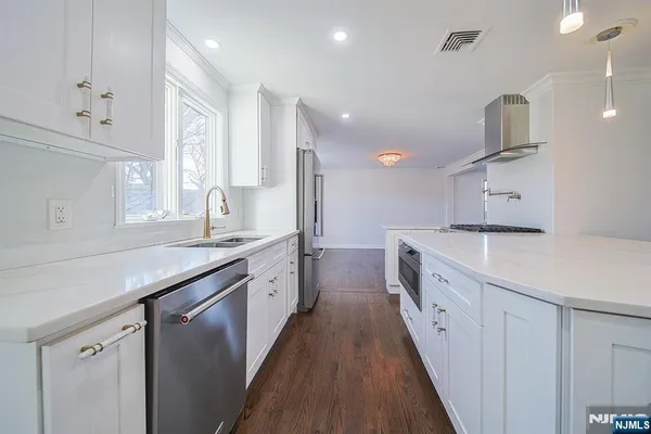 a kitchen with granite countertop a sink and a refrigerator