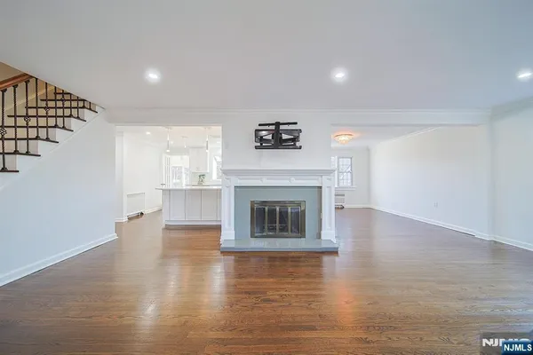a view of a livingroom with wooden floor and a fireplace