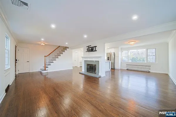 an empty room with wooden floor and fireplace