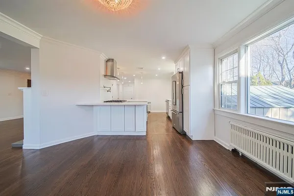 a view of kitchen with wooden floor and electronic appliances