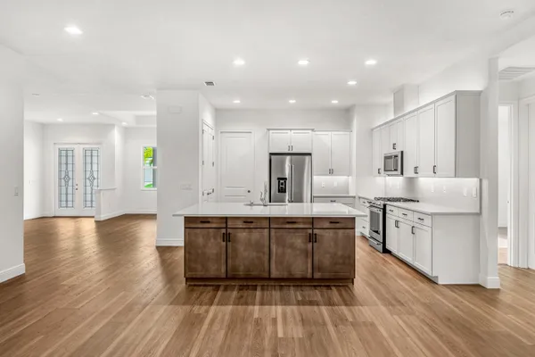 a large kitchen with stainless steel appliances granite countertop a stove a sink and a refrigerator