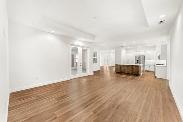 a view of a kitchen with wooden floor and a window