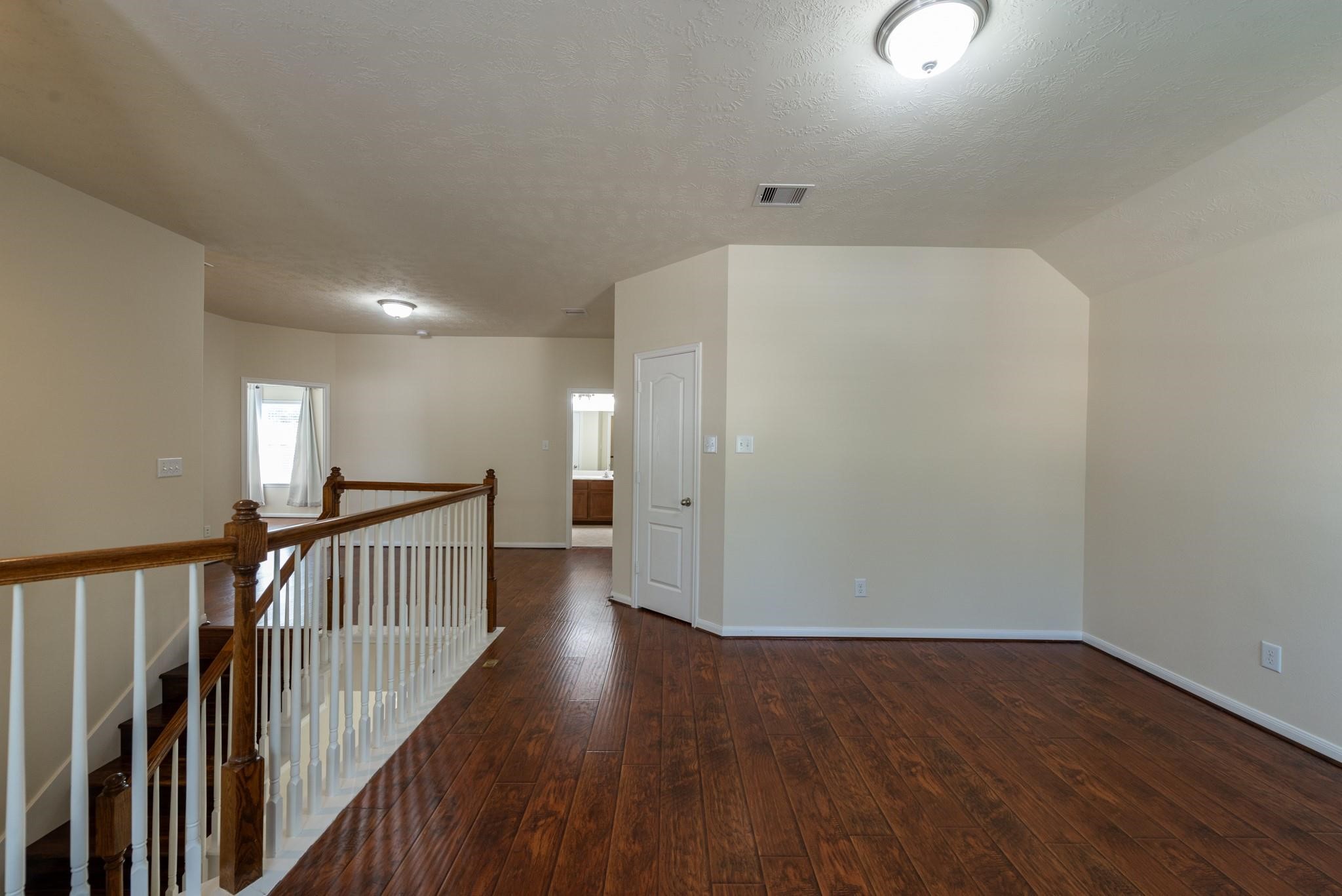 6402 Addlestone Ridge Lane Katy, TX 77494 - Photo 21 of 25 Open and versatile upstairs game room overlooks the staircase and serves as the central hub connecting all bedrooms. With rich wood-look flooring and ample space, it's perfect for a media room, play area, home office, study zone, or second family room.