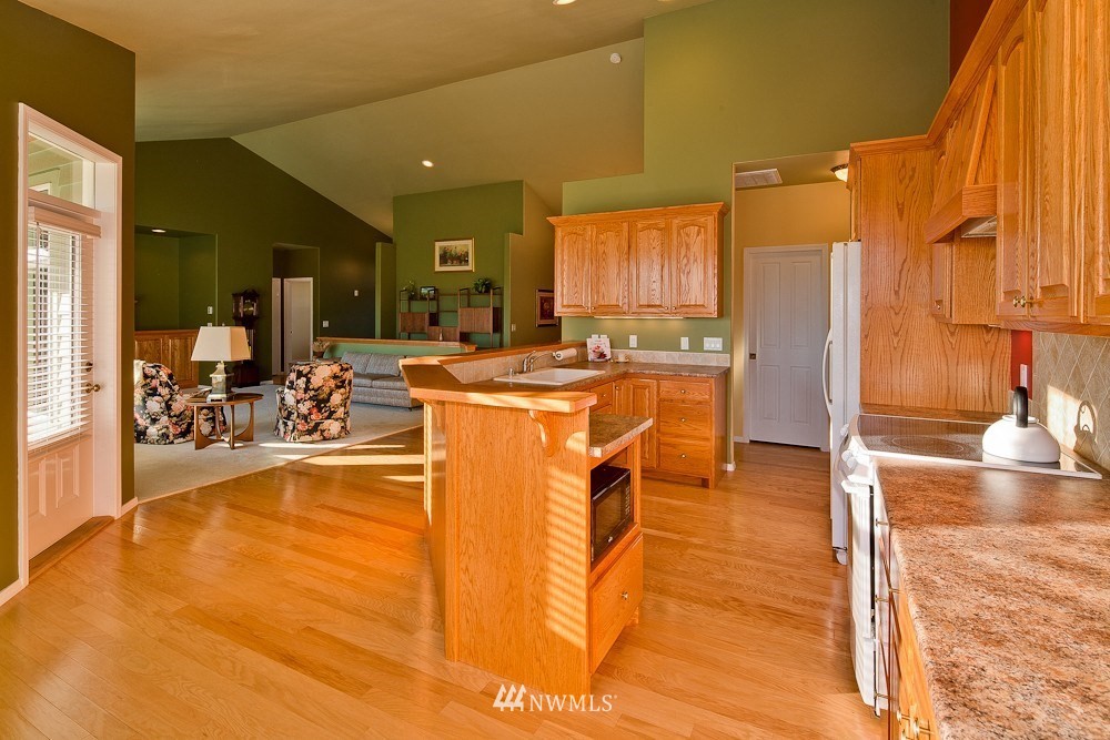 6829 Raspberry Dr. Everson, WA 98247 - Photo 8 of 17 a view of a kitchen with kitchen island stainless steel appliances a sink and cabinets