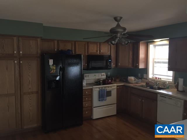 4248 Roundabout Road Louisa, VA 23093 - Photo 3 of 9 a kitchen with stainless steel appliances granite countertop a refrigerator a sink dishwasher a stove and a dining table with wooden floor