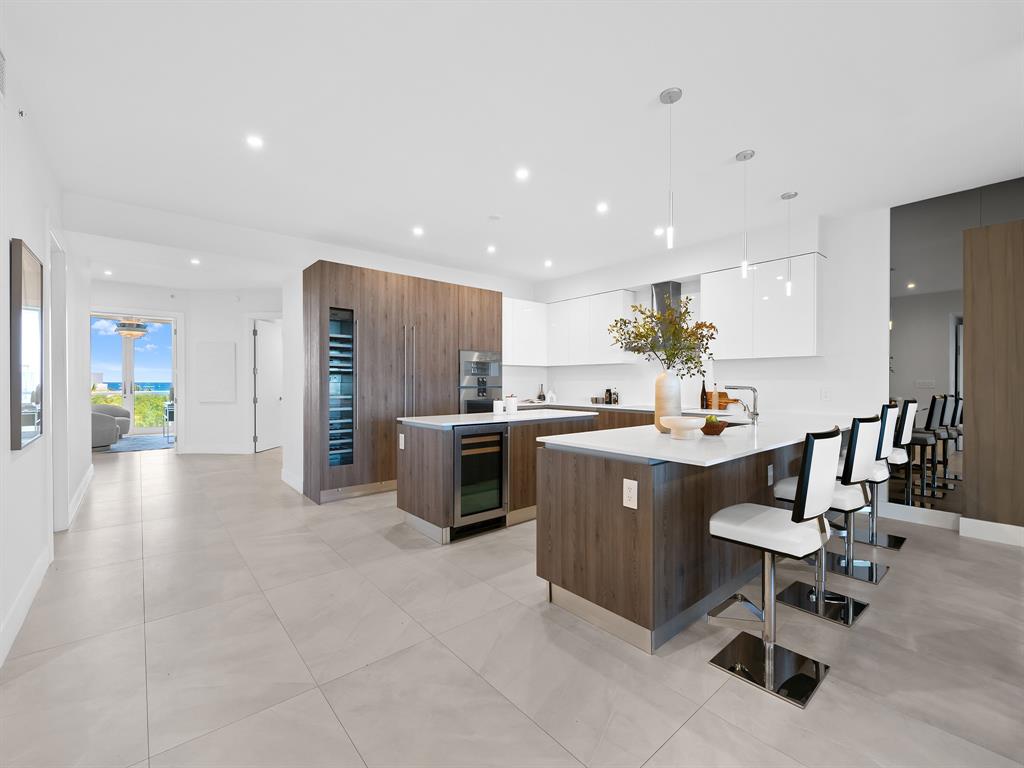 321 North Birch Road, Unit 502 Fort Lauderdale, FL 33304 - Photo 7 of 56 a kitchen with stainless steel appliances kitchen island granite countertop a sink and cabinets