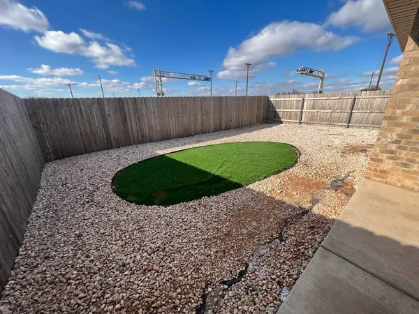 a view of a backyard with wooden fence