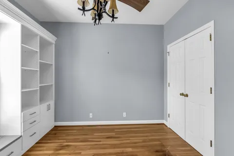 a view of an empty room with closet and a window